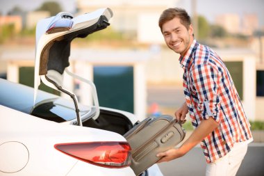 İyi adam bavulu arabaya koyarak