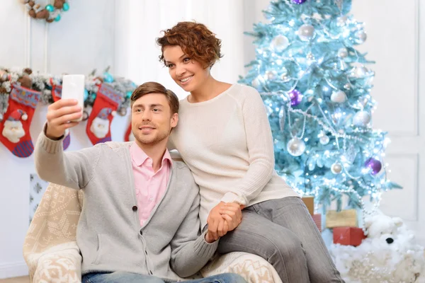 Loving couple sitting in the arm chair — Stock fotografie