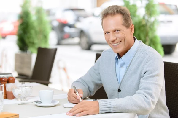 Aardige man zitten aan de tafel — Stockfoto