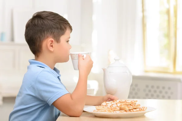 Cheerful boy sitting in the kitchen — Stock Photo, Image