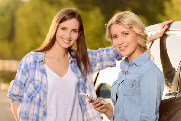 Trevliga kvinnor står nära bil — Stockfoto