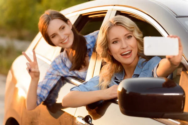 Mulheres alegres sentadas no carro — Fotografia de Stock