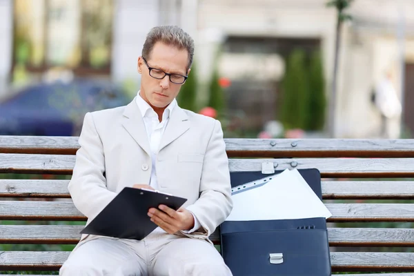 Schöner Mann sitzt auf der Bank — Stockfoto