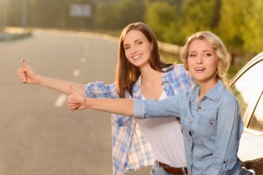 Hoş kızlar arabanın yakınında daimi