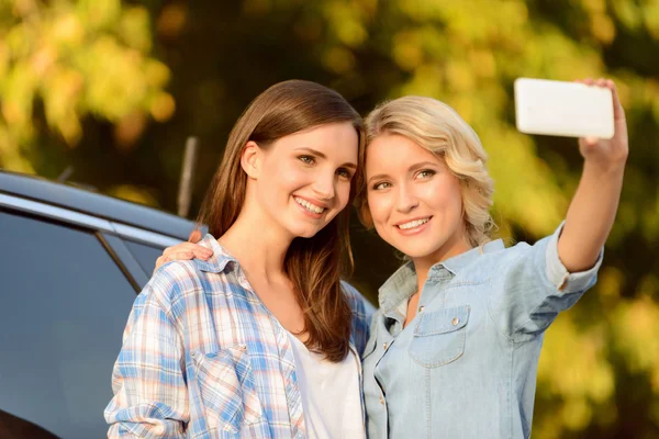 Meninas agradáveis de pé perto do carro — Fotografia de Stock