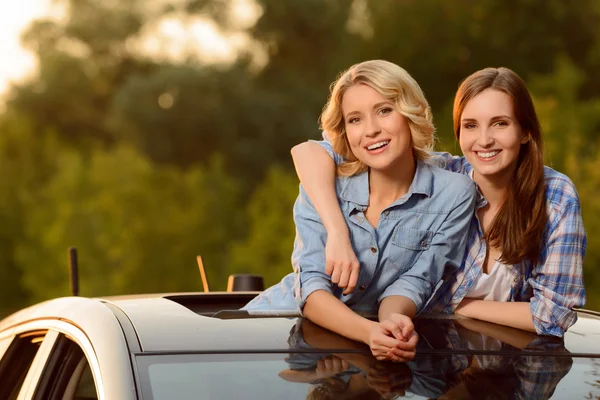 Veselé dívky sedí v autě — Stock fotografie