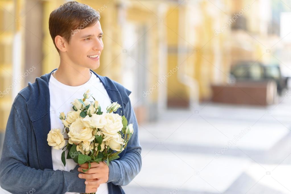Photo holding flowers Handsome guy holding flowers — Stock Photo