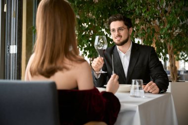 Lüks bir restoranda kadeh kaldıran, flört eden, birbirine bakan sevgi dolu bir çift. Romantizm, tarih, ilişki kavramı