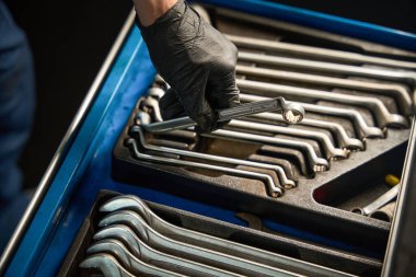 Kafkas eldivenli el geniş bir alet takımından İngiliz anahtarı seçer