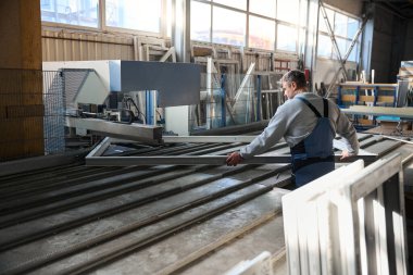 Profesyonel işçi fabrikadaki PVC kapı ve pencereleri birleştiriyor.