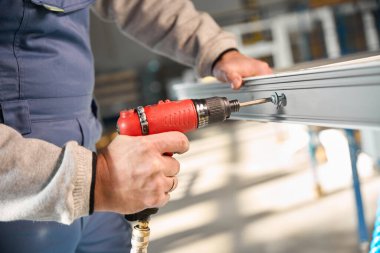 Profesyonel fabrikada PVC pencereler inşa eden tanınmayacak kadar yetenekli bir işçi.