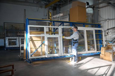 Profesyonel fabrikada PVC pencereler inşa eden çok yetenekli bir işçi.