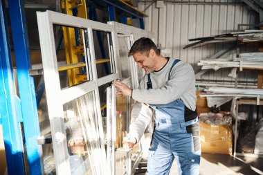 Profesyonel işçi fabrikadaki PVC kapı ve pencereleri birleştiriyor.