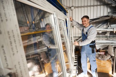 Profesyonel fabrikada PVC pencereler inşa eden çok yetenekli bir işçi.