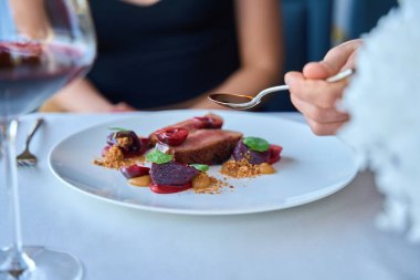 Garsonun lokantadaki kadına et için sos eklerken çekilmiş bir fotoğrafı.