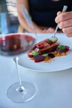 Kadın için beyaz tabakta et sosuyla kaplanmış garsona yaklaş.