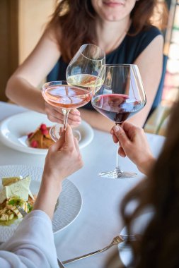 Genç kadınların restoranda kadeh tokuştururken çekilmiş bir fotoğrafı.
