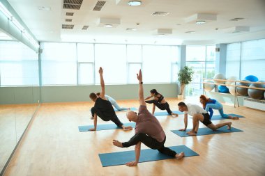 Spor salonundaki spor salonunda yoga dersi veren bir grup sporcu. Sağlıklı yaşam tarzı, spor, jimnastik, yoga stüdyosu