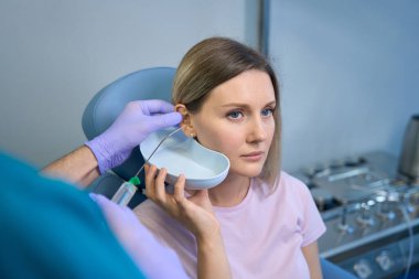 Tıp merkezinde kulakları temizlenen bir kadın hasta. Otolaryngology konsepti