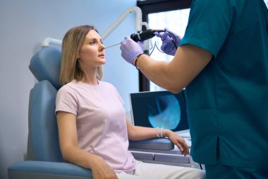 Otolaryngologist, klinikte kadın hasta burnunu video endoskopla inceliyor. Otolaryngology konsepti