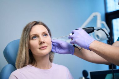 KBB doktoru klinikteki kadın kulağına endoskopi uyguluyor. Otolaryngology konsepti