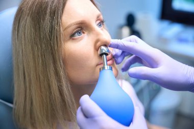 Klinikteki bayana burun ameliyatı yapan koruyucu eldivenler giyen otolaringolojistleri kapatın. Burun tıkanıklığı, sinüzit, alerji konsepti.