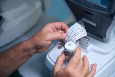 Optik tıbbi cihazlar kullanarak göz doktorlarının ellerini kapatın. Optometri kavramı