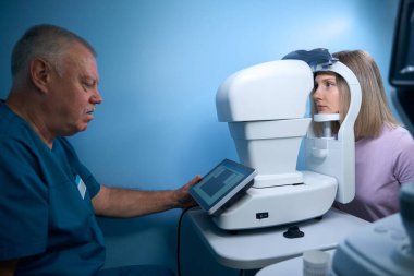 Göz hekimliği kliniğinde doktor ve hasta, göz görüşünü kontrol ediyor. Teşhis Cihazı. Tıp, sağlık hizmeti kavramı