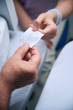 Optalmoloji kliniğinde vizyon muayenesinden sonra test sonuçlarını alan genç bayana yakın çekim. Tıp, sağlık hizmeti kavramı