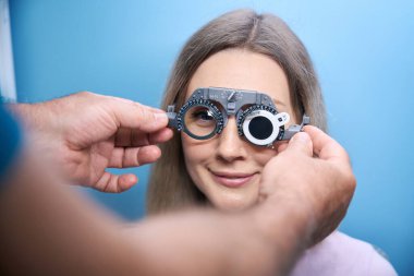 Optik klinikte görme yetisini test eden genç bir kadın var. Tıp, sağlık hizmeti kavramı