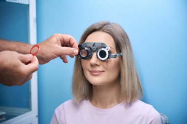 Erkek gözlükçü, göz hekimliği kliniğinde yeni gözlük için kadının gözlerini kontrol ediyor. Tıp, sağlık hizmeti kavramı