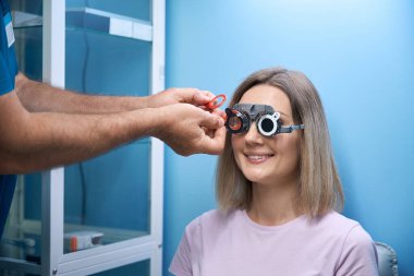 Optalmoloji kliniğinde lens seçerken gözlük takan mutlu kadın hasta. Tıp, sağlık hizmeti kavramı