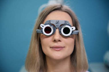 Deneme çerçeveli gözlüklü genç bir kadının kameraya bakışını kapatın. Tıp, sağlık hizmeti kavramı