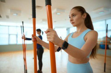 Jimnastik sopaları tutan genç ve güzel kadınlar spor salonunda birlikte egzersiz yapıyorlar. Fitness, spor, eğitim, spor salonu ve yaşam tarzı konsepti