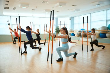 Jimnastik barları kullanan bir grup insan spor salonunda birlikte çalışıyor. Fitness, spor, eğitim, spor salonu ve yaşam tarzı konsepti