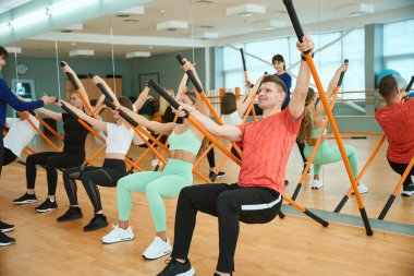 Sportif insanlar jimnastik sopalı bir eğitmenle antrenman yapıyor. Fitness, spor, eğitim, spor salonu ve yaşam tarzı konsepti