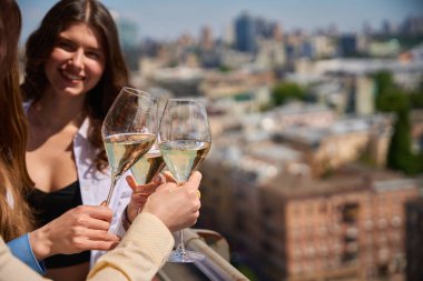 Balkondaki açık hava partisinde gülümseyen kız arkadaşların şampanya içerken çekilmiş bir fotoğrafı. Boşluğu kopyala