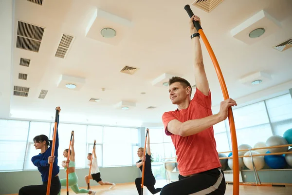 Sportif insanlar spor salonunda jimnastik sopalarıyla antrenman yapıyor. Fitness, spor, eğitim, spor salonu ve yaşam tarzı konsepti