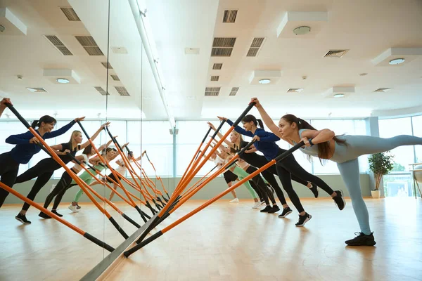 Beden eğitiminde jimnastik sopaları kullanan bir grup insan. Fitness, spor, eğitim, spor salonu ve yaşam tarzı konsepti