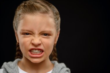 Little girl standing on black background