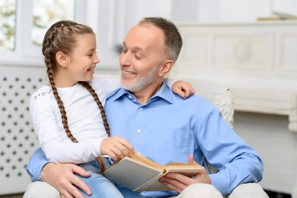 Grand-père avec petite fille lecture livre — Photo