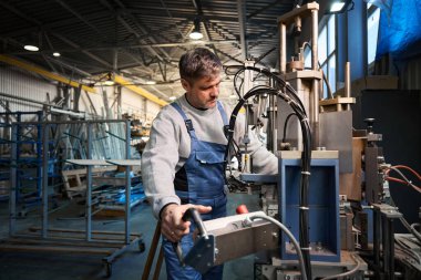 Fabrikadaki farklı PVC pencereleriyle çalışan profesyonel üretim işçileri