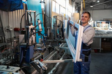 PVC pencere ve kapı montajı yapan fabrikada çalışan el işçisi