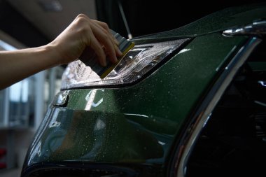 Elin kapanışı nemli araba far lenslerinin nemli yüzeyi ve cam sileceği.