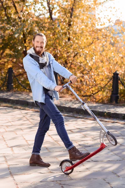 Homem positivo montando uma scooter — Fotografia de Stock