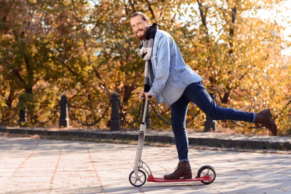 Hombre positivo montando un scooter — Foto de Stock