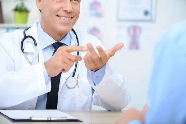 Smiling cardiologist talking to the patient — Stock Photo, Image