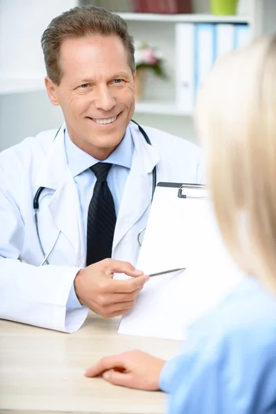 Cardiologista sorridente conversando com o paciente — Fotografia de Stock