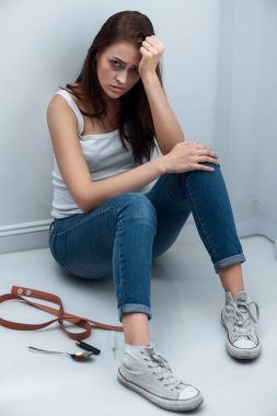 Drug addict sitting on the floor