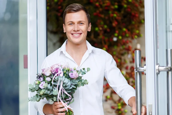 Nice man going out of flower shop — Zdjęcie stockowe